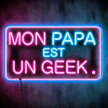 DALL·E 2024-08-22 15.28.39 – A neon sign with the text ‘Mon Papa Est Un Geek’ in a bold, retro font. The sign is glowing in a vibrant blue and pink color scheme, with the neon tub